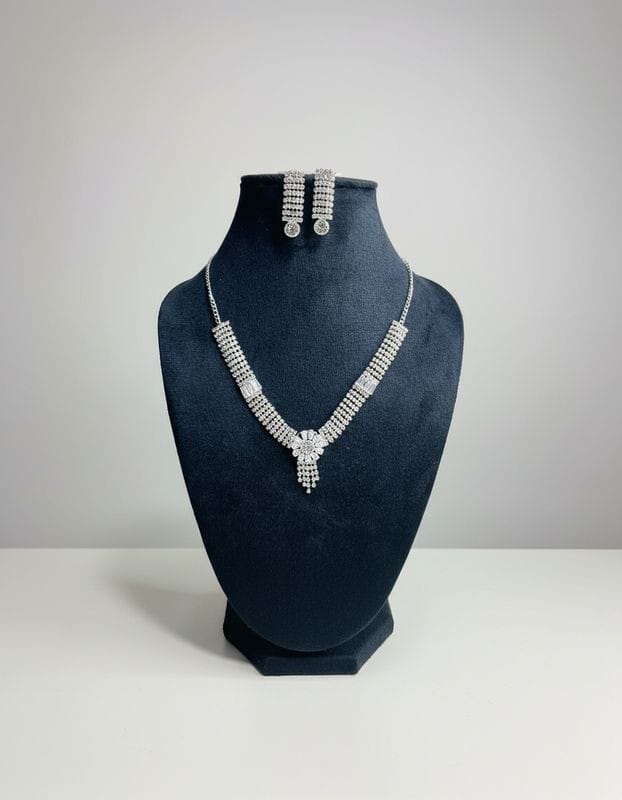 Jewelry set with necklace and earrings on a black mannequin bust against a gray background
