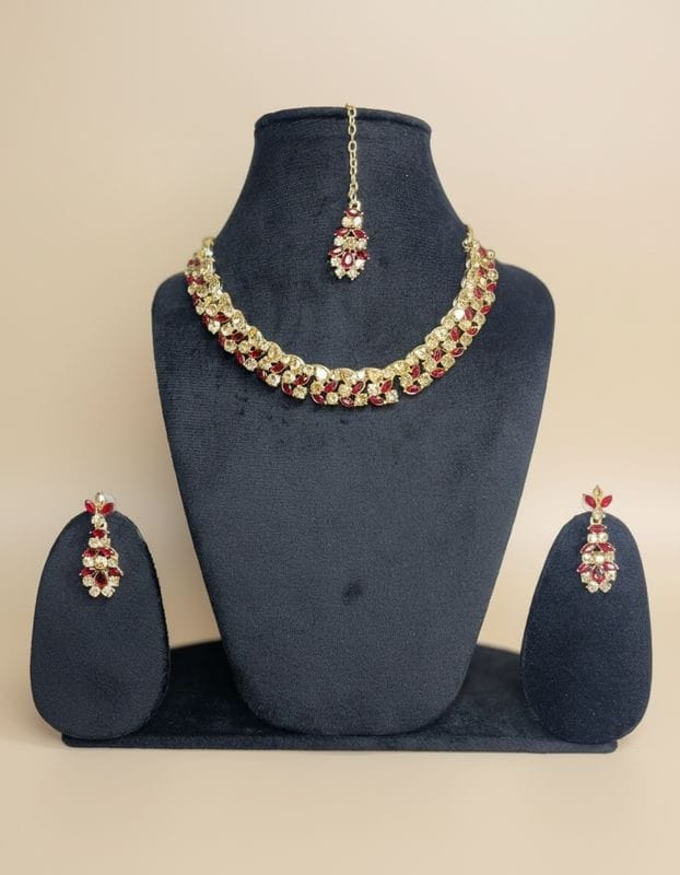 Jewelry set with necklace, earrings, and tikka on a blue mannequin bust.