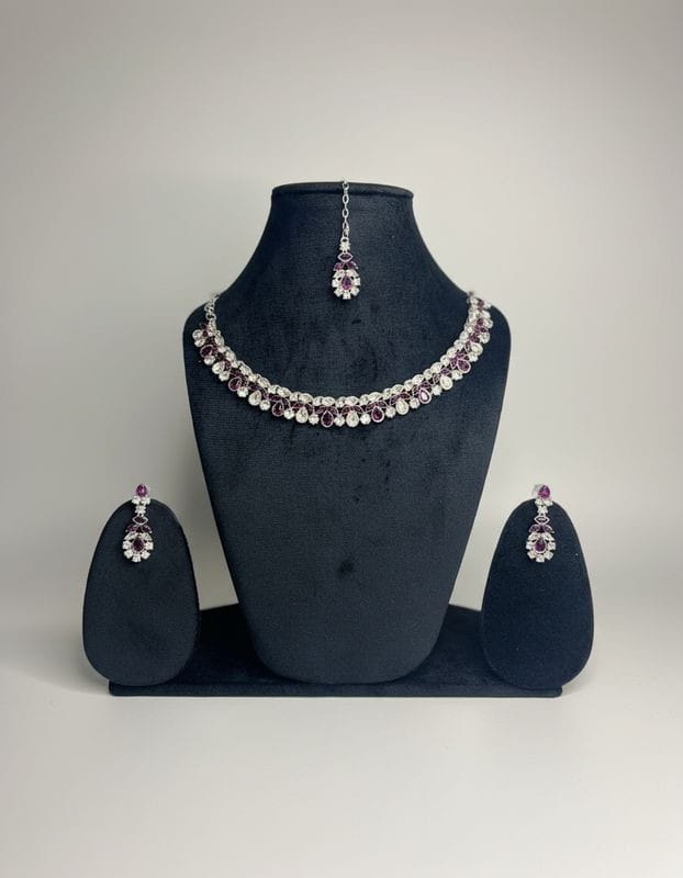 Jewelry set with necklace and earrings on a black mannequin bust against a gray background