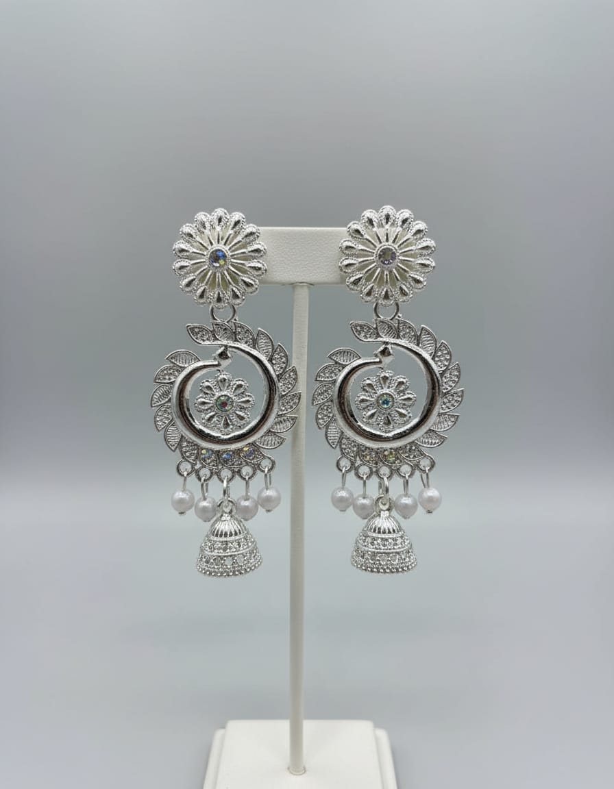 Silver earrings with floral designs and pearl accents on a gray background